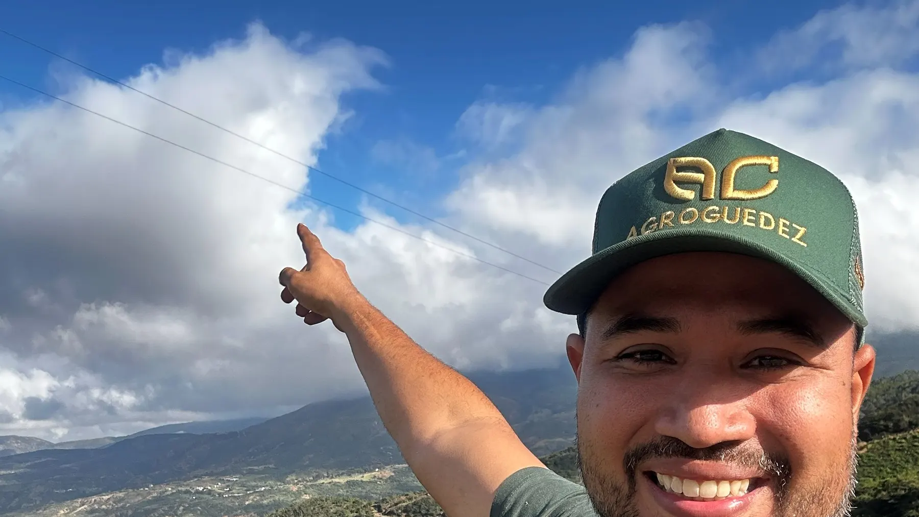 Carlos Guedez señalando el paisaje de una finca con ganado